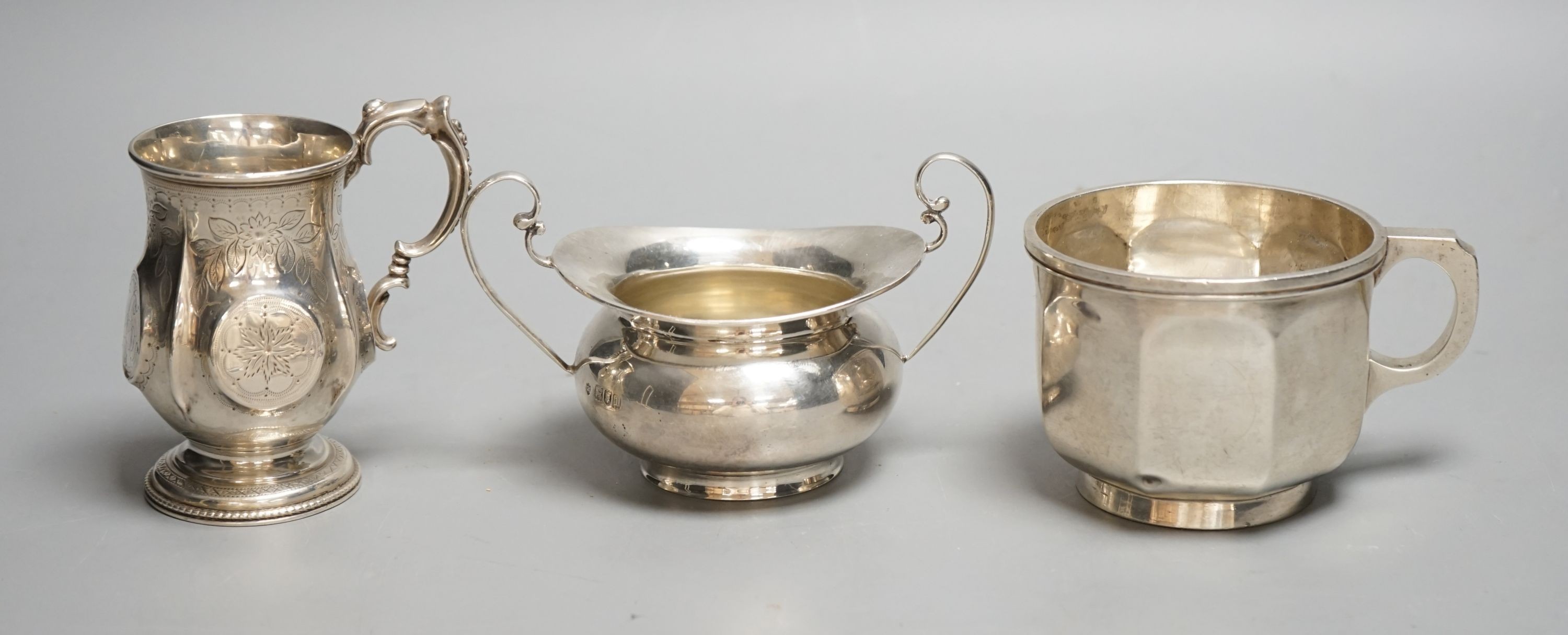 A Victorian silver christening mug, Birmingham, 1874, a later silver mug and a two handled sugar bowl